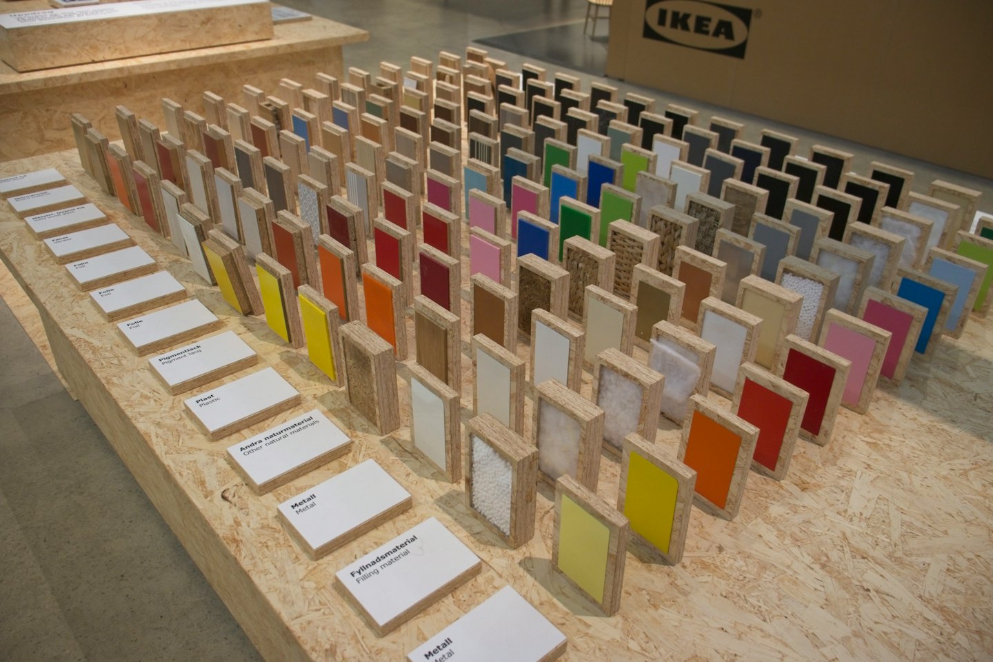 Material and color samples are arranged on a wooden table.